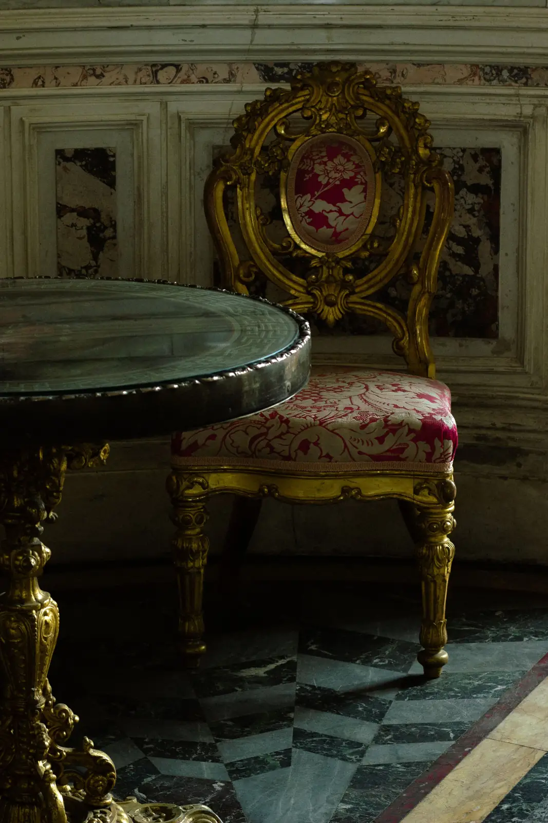 A gilded chair in crimson damask